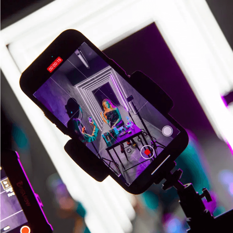 Siedząca modelka w obiektywie smartfona